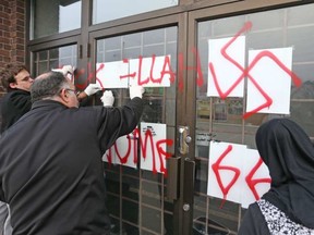Hate graffiti on the Ottawa Mosque on Northwestern Ave being removed, Nov.18, 2016. JEAN LEVAC / POSTMEDIA NEWS