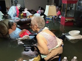 In this Sunday, Aug. 27, 2017, photo provided by Trudy Lampson, residents of the La Vita Bella nursing home in Dickinson, Texas, sit in waist-deep flood waters caused by Hurricane Harvey. (Trudy Lampson via AP)