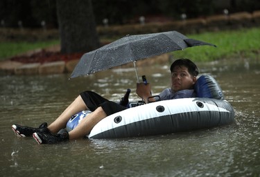HOUSTON, TX - AUGUST 28:  A boy rides a pool float in his front yard after severe flooding following Hurricane Harvey in the Cypresswood Creek subdivision in north Houston August 28, 2017 in Houston, Texas. Harvey, which made landfall north of Corpus Christi late Friday evening, is expected to dump upwards of 40 inches of rain over the next couple of days.  (Photo by Win McNamee/Getty Images) *** BESTPIX ***