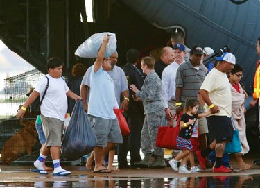 Evacuees from Tropical Storm Harvey arrive at Dallas Love Field on a military aircraft in Dallas on Monday, Aug. 28, 2017. Floodwaters reached the rooflines of single-story homes Monday and people could be heard pleading for help from inside as Harvey poured rain on the Houston area for a fourth consecutive day after a chaotic weekend of rising water and rescues. (David Woo/The Dallas Morning News via AP) ORG XMIT: TXDAM108