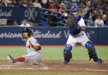 Mookie Betts #50 of the Boston Red Sox is forced out at home plate with the bases loaded in the seventh inning during MLB game action as Raffy Lopez #1 of the Toronto Blue Jays completes the inning-ending double play at Rogers Centre on August 28, 2017 in Toronto, Canada. (Photo by Tom Szczerbowski/Getty Images)