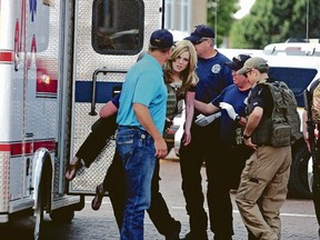 An injured woman is carried to an ambulance in Clovis, N.M., on Monday, Aug. 28, 2017, as authorities respond to reports of a shooting inside a public library. (Tony Bullocks/The Eastern New Mexico News via AP)