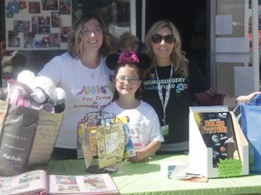 From the left, Jen MacKinnon, Josie MacKinnon and Soula Milonas stand together at the toy drive on Aug. 25 (Joseph Quigley | Whitecourt Star).