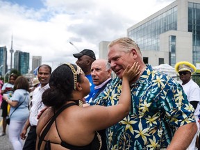 A participant greets Doug Ford during the Grand Parade at the Caribbean Carnival in Toronto on Saturday, August 5, 2017. (THE CANADIAN PRESS/Christopher Katsarov)