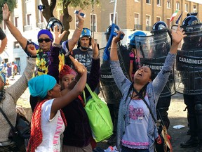 Police officers force migrants to leave the area around a building they were occupying in downtown Rome Thursday, Aug. 24, 2017. (AP Photo/Fernanda Pesce Blazquez)