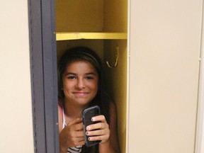 Kaylie Rogers-Oliver tries out a Great Lakes Secondary School locker. She was at the school with a family member who was registering for classes. (NEIL BOWEN/Sarnia Observer)