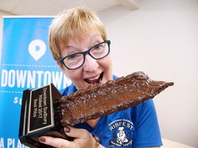 Maureen Luoma, executive director of Downtown Sudbury, hams it up for the camera as she shows off the best ribs award at a press conference on Tuesday. Downtown Sudbury Ribfest takes place this weekend, with professional rib teams on hand and plenty of entertainment for the whole family. For more information, go to www.downtownsudbury.com. (Gino Donato/Sudbury Star)