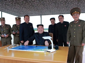 This Aug. 29, 2017 photo distributed on Wednesday, Aug. 30, 2017, by the North Korean government, North Korean leader Kim Jong Un, center, smiles as Kim inspects the test launch of a Hwasong-12 intermediate range missile in Pyongyang, North Korea. (Korean Central News Agency/Korea News Service via AP)