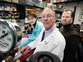 In this Feb. 5, 2009 file photo, University of Massachusetts professor Dr. James Dobson, Jr., center, poses with his wife Susan, left, and Teresian Carmelite Prior Dennis-Anthony Wyrzykowski, right, in Dobson's laboratory at the University of Massachusetts Medical School in Worcester, Mass. (AP Photo/Steven Senne, File)