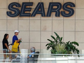 In this file photo, shoppers walk by the sign at a Sears store in Pittsburgh, Pennsylvania. (AP Photo/Gene J. Puskar)