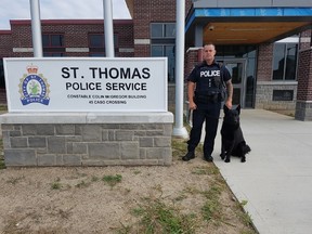 Constable Sean James and his dog Trax stand outside the St. Thomas Police Service building on Wednesday morning. Trax has retired from duty due to a medical condition. (Laura Broadley/Times-Journal)