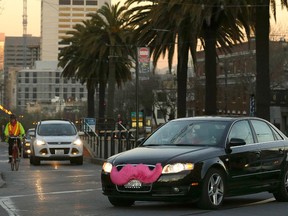 In this Jan. 17, 2013 file photo, a Lyft car drives crosses Market Street in San Francisco. (AP Photo/Jeff Chiu, File)