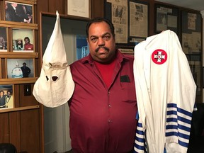 Daryl Davis stands with the robe of a former KKK member in his home in Silver Spring, Maryland. (Rachel Chason, The Washington Post)