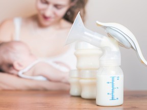 In this stock photo, a mother breastfeeds her newborn baby as a breast pump is seen in the foreground. (Getty Images)