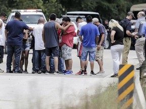 Family members react as a van is pulled out of the Greens Bayou with the bodies of six family members in Houston on Wednesday, Aug. 30, 2017. The van was carried into the bayou during Tropical Storm Harvey as the water went over the bridge. (Elizabeth Conley/Houston Chronicle via AP)