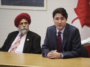 Prime Minister Justin Trudeau speaks at a roundtable on employment insurance while MP Darshan Kang looks on March 29, 2016 in Calgary. (LYLE ASPINALL/POSTMEDIA)
