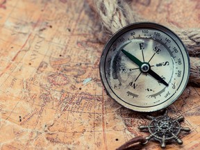 An antique compass sits on a map in this stock image. (Getty Images)