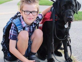 Kenner Fee poses with his service dog Ivy in an undated handout photo. Ontario's human rights tribunal has ruled that Kenner, a nine-year-old autistic boy, cannot bring his service dog with him into his classroom. (THE CANADIAN PRESS/HANDOUT)