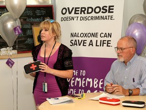 Kingston, Frontenac, Lennox & Addington Public Health nurse Rhonda Lovell holds a Naloxone kit as Medical Officer of Health Dr. Kieran Moore looks on during a news conference to mark International Overdose Day at the Street Health Centre in Kingston on Thursday. (Ian MacAlpine/The Whig-Standard)