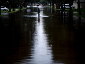 A woman walks down a flooded road during the aftermath of Hurricane Harvey in Houston, Texas. (GETTY IMAGES/PHOTO)
