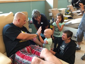 Paisley helps her dad Moe Amyotte bandage up after donating blood as mother Amy Millette and sister Joile watch at Canadian Blood Services in Winnipeg on Aug. 31, 2017 to help kick off Childhood Cancer Awareness Month. Jason Friesen/Winnipeg Sun