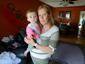 Sascha Ackland holds her one-year-old daughter Marley in her Old South London home on Thursday. Marley was born with a congenital bone defect so rare that treatment is only available in the United States. Friends and family have established an online fundraiser to collect money for the procedure. MORRIS LAMONT/THE LONDON FREE PRESS /POSTMEDIA NETWORK