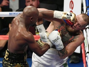 LAS VEGAS, NV - Floyd Mayweather Jr. hits Conor McGregor in the sixth round of their super welterweight boxing match at T-Mobile Arena on August 26, 2017 in Las Vegas, Nevada. Mayweather won by 10th-round TKO. Ethan Miller/Getty Images