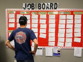 Jordan Vandermeer looks over the job board in the Employment Resource Centre in the Bayside Mall in Sarnia. Vandermeer, who drives a fuel truck, noticed their weren't many listings in his work. He worked in the various fuel plants since he was 18, but was laid off. Mike Hensen/The London Free Press/Postmedia Network