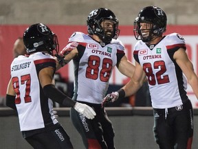 Ottawa Redblacks wide receiver Greg Ellingson, right, celebrates his touchdown against the Montreal Alouettes with teammates Joshua Stangby, left, and Brad Sinopoli during CFL action on Aug. 31, 2017. (THE CANADIAN PRESS/Paul Chiasson)