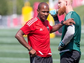 Head coach Julian de Guzman pats ’keeper Andrew MacRae on the arm during Ottawa Fury practice this week. (WAYNE CUDDINGTON/Postmedia Network)