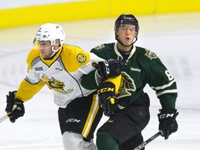 London Knight Cliff Pu locks arms with Sarnia Sting Hugo Leufvenius during the first period of their OHL preseason game at Budweiser Gardens in London, Ont. on Friday.  (DEREK RUTTAN, The London Free Press)