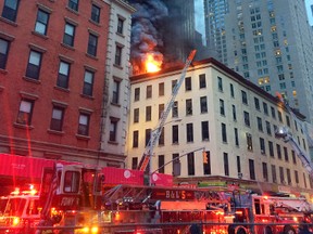 Fire and smoke shoot through roof of a five-story building, in New York, Friday, Sept. 1, 2017. The building has retail space on the first floor and apartments above, in Manhattan's Tribeca neighborhood. (AP Photo/David Caruso)