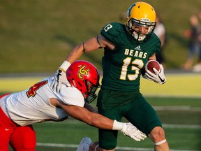 University of Alberta Golden Bears Daniel Bubelenyi (13) fights ff a tackle from University of Calgary Dinos' Boston Rowe (24) at Foote Field, in Edmonton Friday Sept. 1, 2017.