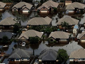 Homes are surrounded by water from the flooded Brazos River in the aftermath of Hurricane Harvey Friday, Sept. 1, 2017, in Freeport, Texas. (AP Photo/Charlie Riedel)