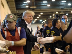 U.S. President Donald Trump passes out food and meets people impacted by Hurricane Harvey during a visit to the NRG Center in Houston, Saturday, Sept. 2, 2017.  (AP Photo/Susan Walsh)