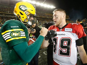 Edmonton Eskimos quarterback Mike Reilly chats with quarterback Bo Levi Mitchell of the Calgary Stampeders after beating the Stamps 31-45 during the CFL's Western Final  at Commonwealth Stadium in Edmonton, Alta., on Sunday November 22, 2015.