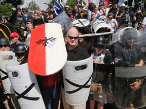 In this Aug. 12, 2017 file photo, white nationalist demonstrators use shields as they guard the entrance to Lee Park in Charlottesville, Va. (AP Photo/Steve Helber, File)