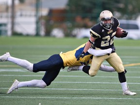 Edmonton Huskies Brandt Burzuk #22 is tackled by Edmonton Wildcats Jayden Dalke  #21 during the Prairie Football Conference junior football game at Clarke Stadium, September 17, 2016.