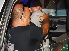 Italian police escort a teenager, at centre with his head covered, in the police headquarters in Rimini, Italy Saturday Sept. 2, 2017. (Manuel Migliorini/ANSA via AP)