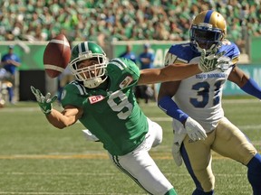 Roughriders wide receiver Nic Demski (left) stretches out for a pass as Blue Bombers defensive back Maurice Leggett looks on during first half CFL action in Regina on Sunday, Sept. 3, 2017. (Mark Taylor/The Canadian Press)