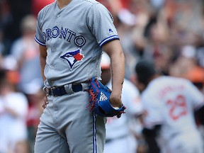 Toronto Blue Jays pitcher Roberto Osuna pauses after giving up a solo home run to Baltimore Orioles Welington Castillo, pictured behind, to tie the game in the ninth inning of a baseball game, Sunday, Sept. 3, 2017, in Baltimore. (AP Photo/Gail Burton)