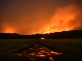 In an Aug. 30, 2017 photo, the Rice Ridge Fire burns in the Lolo National Forest near Woodworth Road northeast of Salmon Lake, Mont. The smoke from massive wildfires hangs like fog over large parts of the U.S. West, an irritating haze causing health concerns, forcing sports teams to change schedules and disrupting life from Seattle to tiny Seeley Lake, Montana. (Rion Sanders/The Great Falls Tribune via AP)