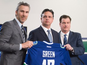 Vancouver Canucks president Trevor Linden, left, and general manager Jim Benning, right, introduce the Canucks new head coach Travis Green during a news conference in Vancouver on April, 26, 2017. (THE CANADIAN PRESS/Jonathan Hayward)
