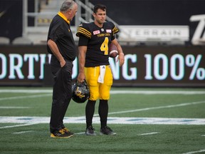 Hamilton Tiger-Cats head coach June Jones speaks with TiCats quarterback Zach Collaros during warm-up before CFL action against the Toronto Argonauts in Hamilton on Sept. 4, 2017. (THE CANADIAN PRESS/Peter Power)