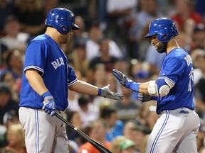 Jose Bautista high fives Kendrys Morales of the Toronto Blue Jays after hitting a solo home run against the Boston Red Sox at Fenway Park on Sept. 4, 2017. (Adam Glanzman/Getty Images)