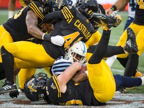 Argonauts’ running back Martese Jackson gets lost in a pile of Hamilton Tiger-Cats after gaining a few yards in Hamilton last night. (The Canadian Press)
