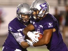 Chris Merchant hands off to Alex Taylor during the Western Mustangs? overtime win against Guelph on Monday. (MIKE HENSEN, The London Free Press)