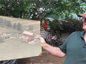 Charlie Doyle holds an older aerial photo of his family’s 100-acre property. If the province had followed through on the expropriation of the land in 1958, Chatham may have looked much different today.