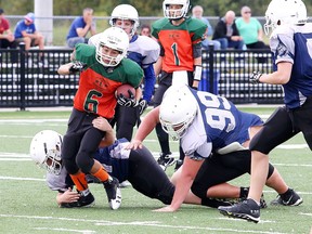 Alessio Capasso of the Hurricanes gets hauled down during Joe MacDonald youth Football bantam action against the Blue Devils in Sudbury, Ont. on Monday September 4, 2017. Gino Donato/Sudbury Star/Postmedia Network