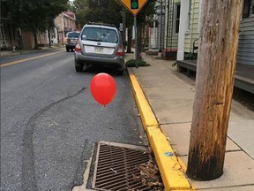 The Lititz police department on Tuesday posted on photos of red balloons a prankster tied to a pair of sewer grates. (Lititz Borough Police Department/Facebook)